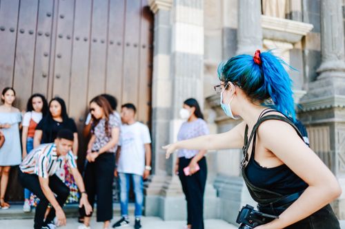 Free A blue-haired photographer directing a group during an outdoor photo shoot. Stock Photo