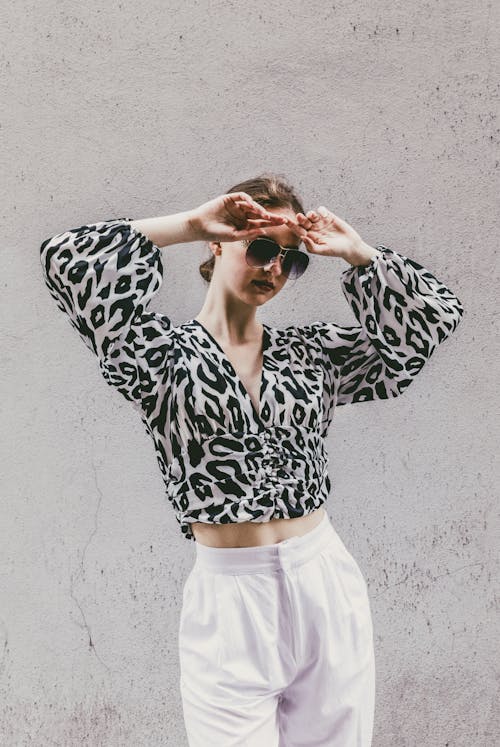 Woman Posing in Leopard Print Blouse and White Pants