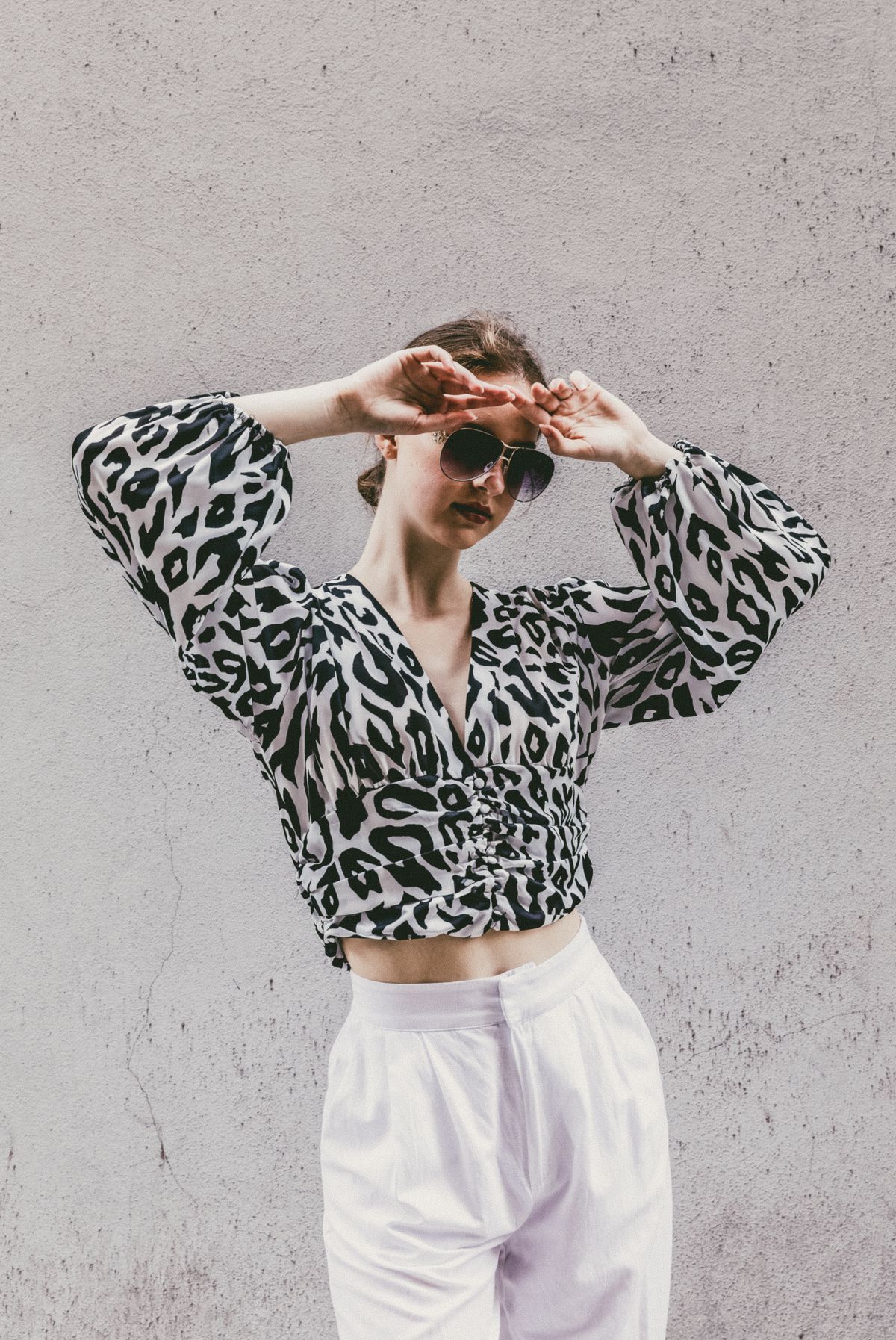 A woman in a leopard-print blouse and white pants — leopard treated as a neutral