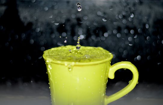 A close-up of a yellow mug with water droplets splashing, captured with bokeh effect.