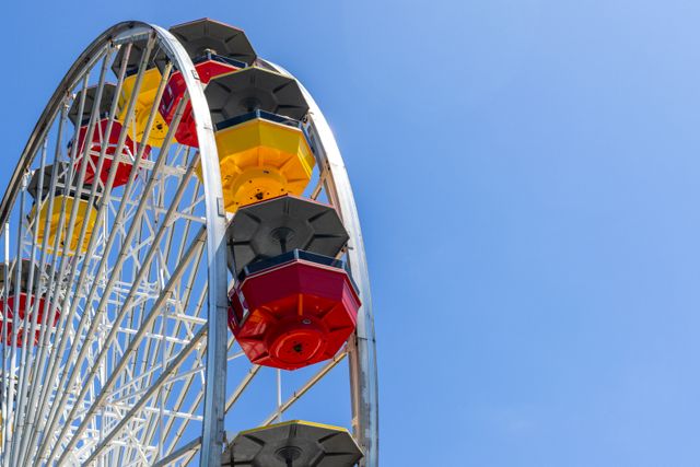 Ferris wheel gondolas against a blue sky — photo by David Brown on Pexels