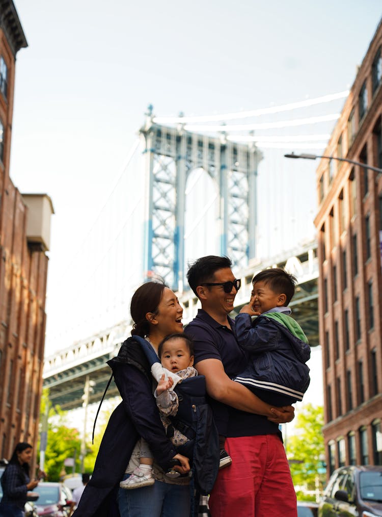 Smiling Mother And Father With Children Near Brooklyn Bridge