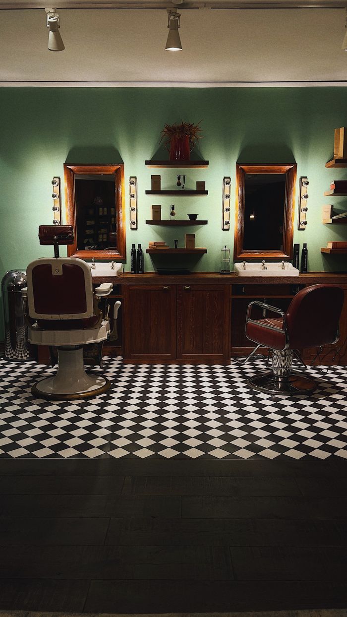 Row of classic barber chairs and mirrors over a black and white checkered floor