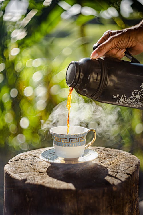 A Person Pouring Tea into a Teacup