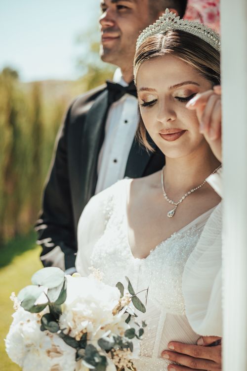Free Beautiful outdoor portrait of a bride and groom in elegant wedding attire, capturing a serene moment. Stock Photo
