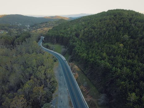 Aerial shot of a winding highway through lush green hills in San Luis Potosí, Mexico.
