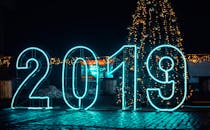 明亮的霓虹灯“2019”标志与圣诞树相映成趣，共同构成了完美的新年庆祝活动