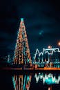 夜晚，一棵装饰着五颜六色灯光的大圣诞树倒映在水面上