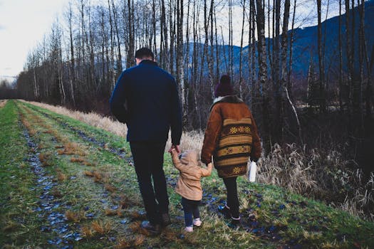 一个凉爽的秋日，一家人手牵手沿着森林小径散步