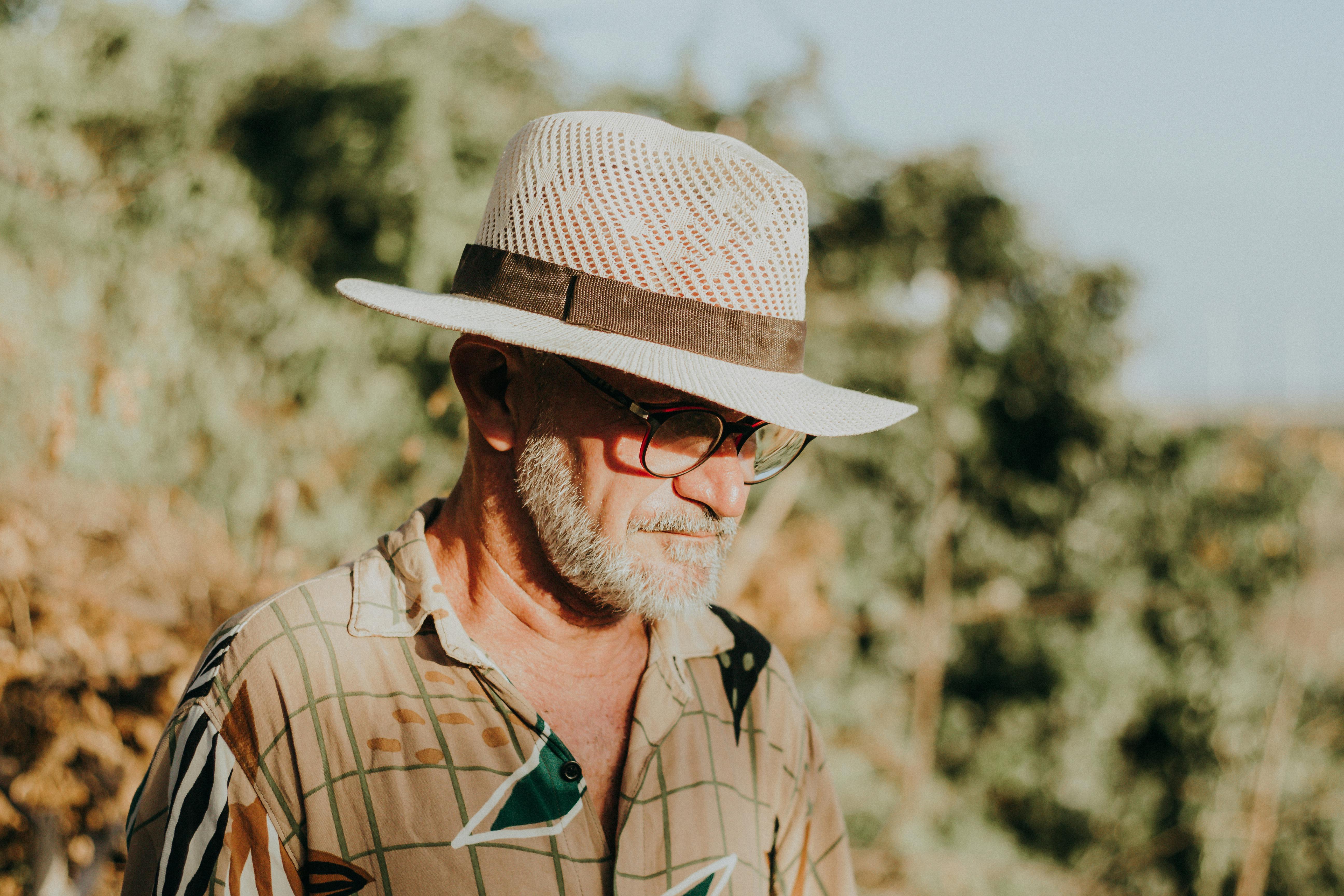 Elderly man with a straw hat enjoys a peaceful day outdoors in Aracati, Brazil.