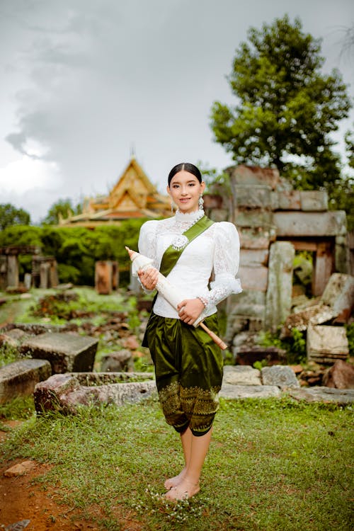 Young Woman in Traditional Clothing Standing in front of a Temple 