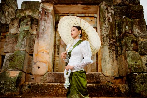 Free A woman in traditional attire poses elegantly with a parasol at ancient ruins, showcasing cultural fashion. Stock Photo