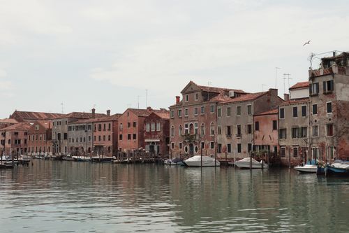 Free Picturesque view of Venice's historic canal lined with colorful buildings and boats. Stock Photo
