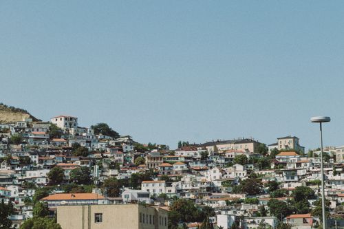 Free Charming urban hillside view with clustered houses under a clear blue sky. Stock Photo