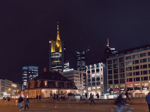 People Walking in Front of Concrete Structures