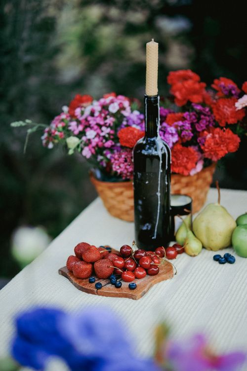 Free A vibrant summer table display with fruits, flowers, and a candle in a bottle, perfect for outdoor gatherings. Stock Photo