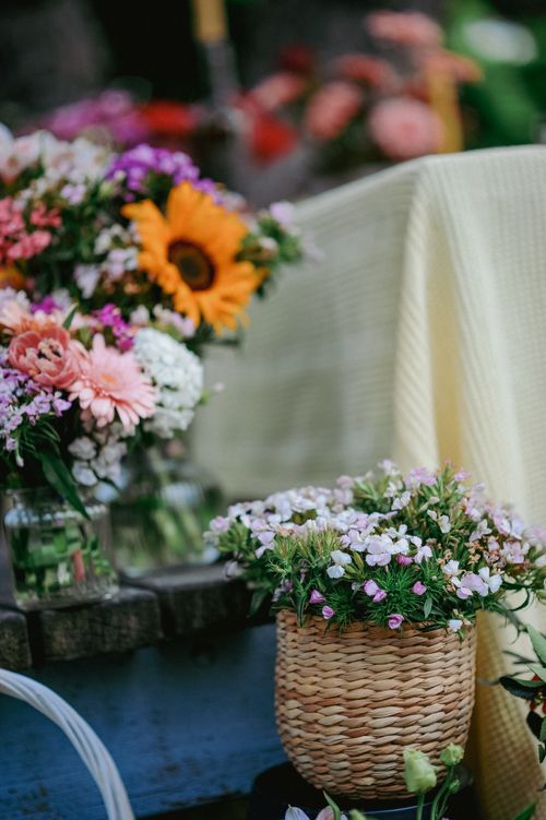 Free Vibrant bouquet display with sunflowers and daisies in a rustic market setting. Stock Photo
