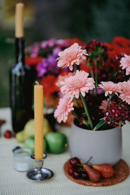 Free Delicate flowers with a lit candle on a decorated table setting a warm, inviting atmosphere. Stock Photo