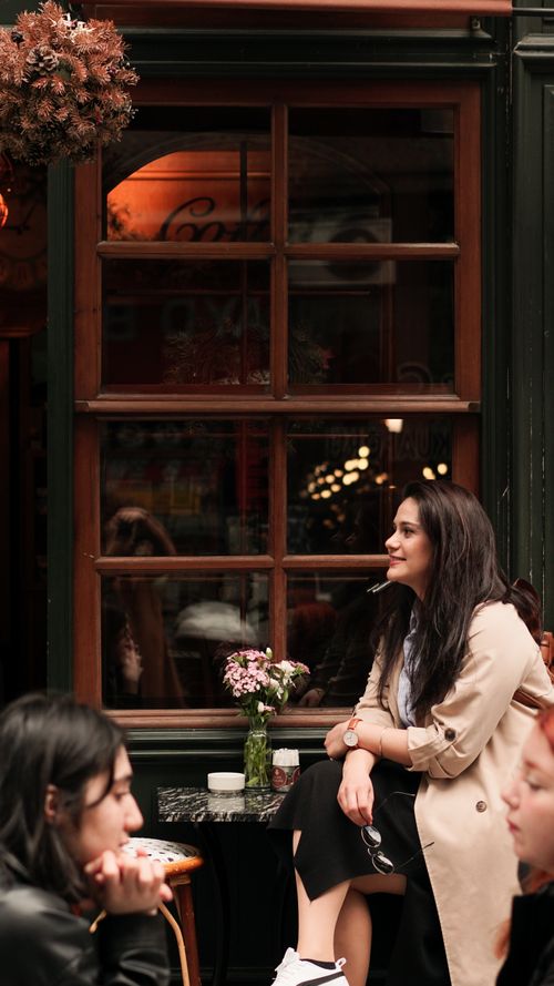 Free A serene moment of a woman enjoying a break at a charming outdoor cafe. Stock Photo