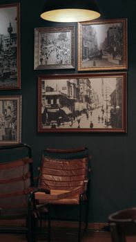 Elegant room featuring vintage photographs and leather seating, illustrating a retro interior design.