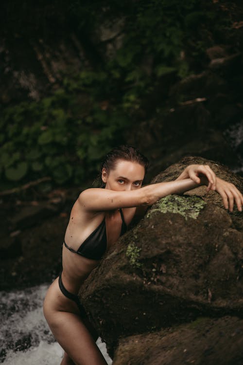 Woman in Bikini Leaning on a Large Rock 