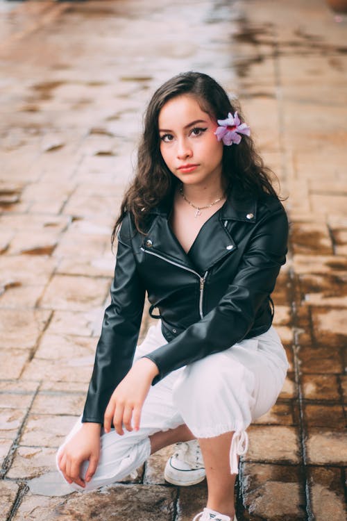 Young Woman in a Leather Jacket Posing on the Sidewalk 