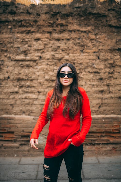 Woman in a Red Blouse and Black Ripped Jeans 