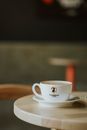 Elegant coffee cup with logo on a wooden table, perfect for cozy cafe ambiance.