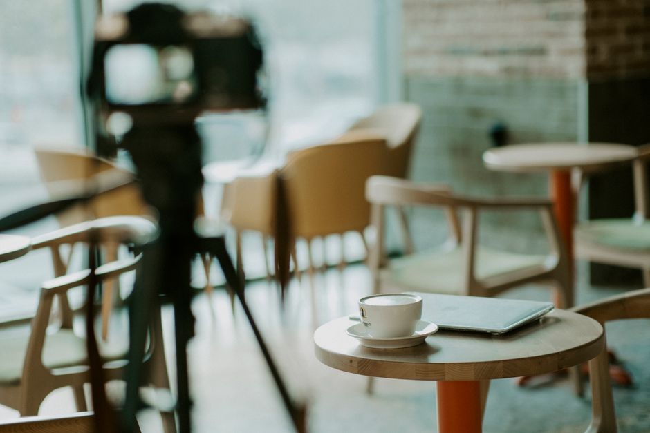 What Testing Data Reveals About Top Cold Brew Coffee Makers Warm café interior with coffee cup on table, laptop, and camera setup.