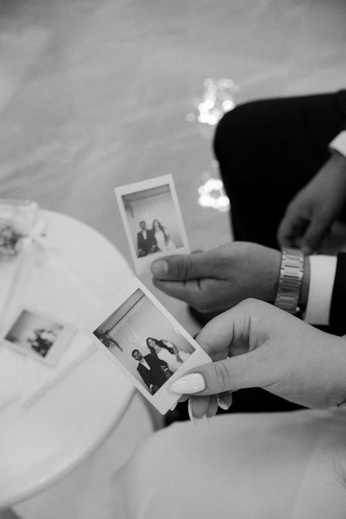 Bride and Groom Holding Polaroid Photos 