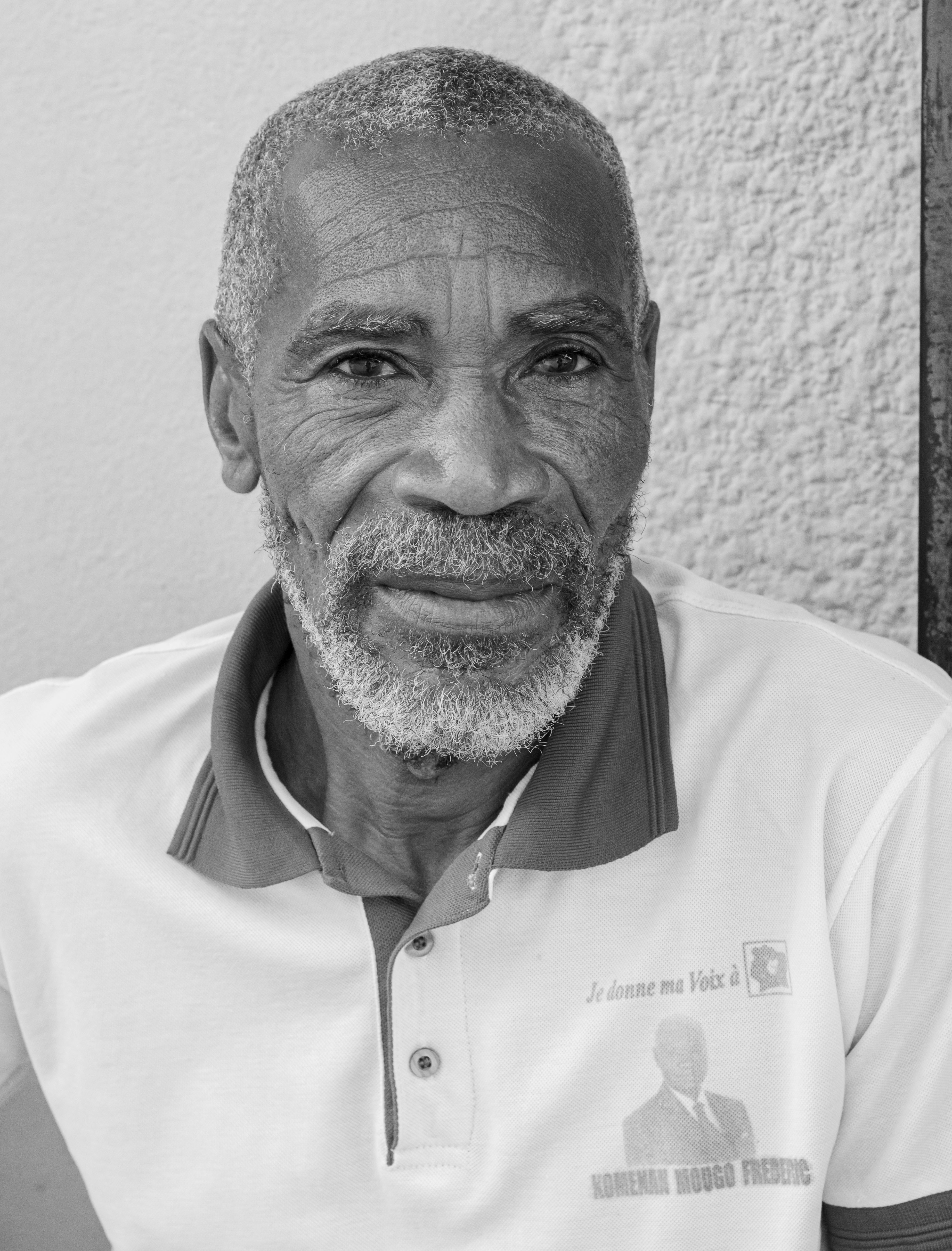 A close-up black and white portrait of an elderly man with a beard and mustache, showcasing wisdom.
