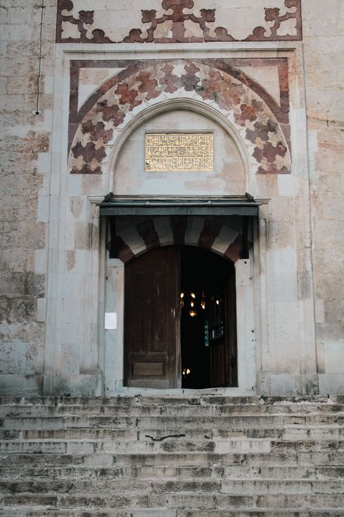 Free A historical mosque entrance with intricate carvings and an open door inviting visitors. Stock Photo