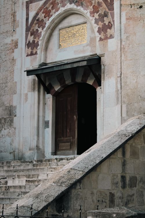 Free Vertical shot of an ornate mosque entrance with decorative stone steps and archway. Stock Photo