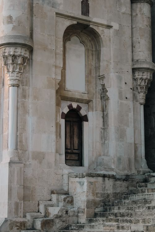 Free Detailed shot of an ornate historical church facade featuring columns and stone steps. Stock Photo