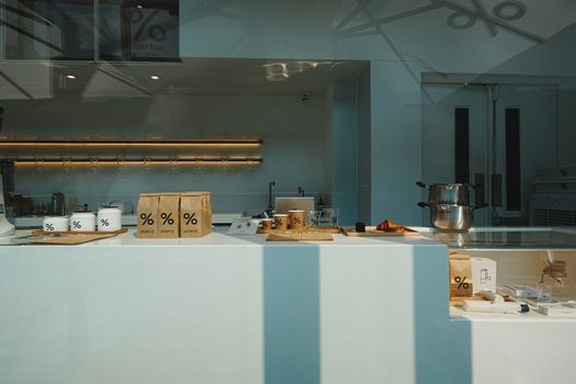 Stylish coffee shop interior showcasing retail items and brewing equipment on a minimalist counter.