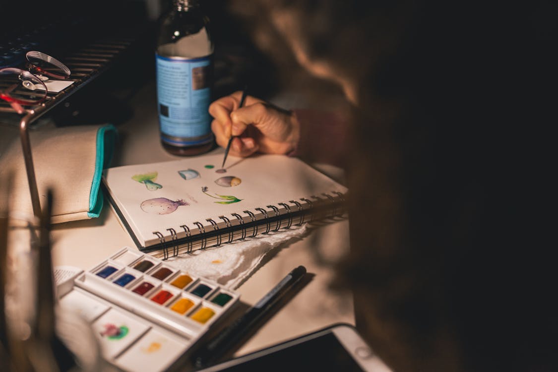 Person Writing Illustration in Spiral Notebook