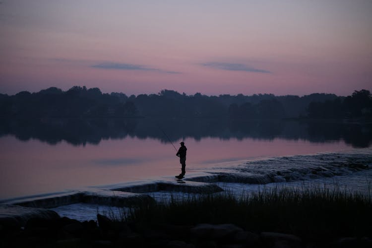 Silhouette Of A Man By The Lake