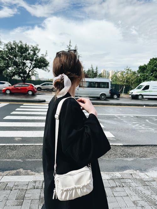 Woman in Black Coat and with Bag Standing near Street