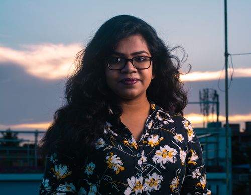 Free Striking portrait of a young woman in a floral shirt during twilight. Stock Photo
