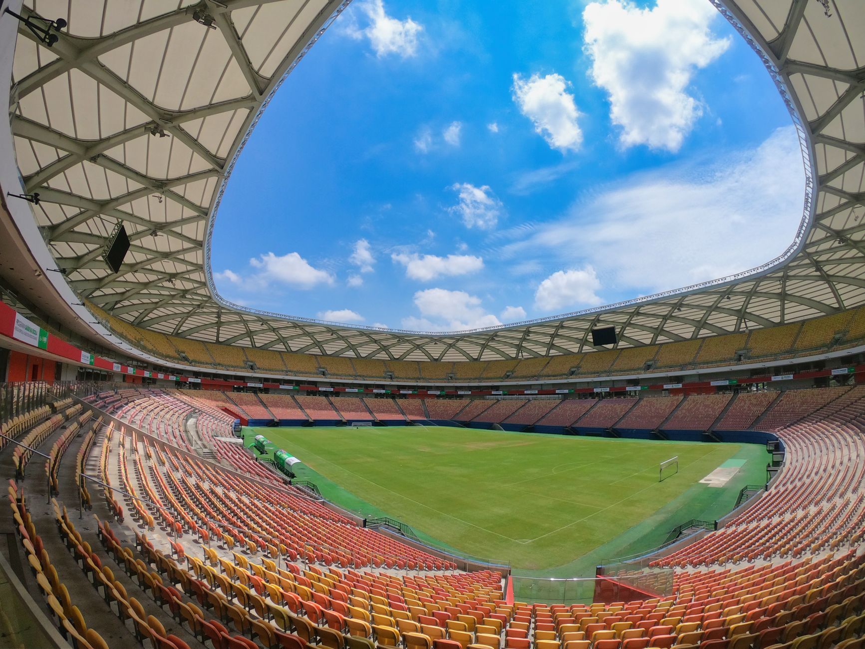 Empty Arena da Amazônia stadium in Manaus under blue skies, showcasing modern architecture.