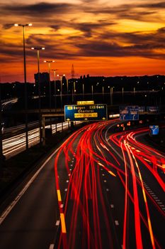 A stunning aerial view of the Vilvoorde highway at sunset with vibrant red light trails.
