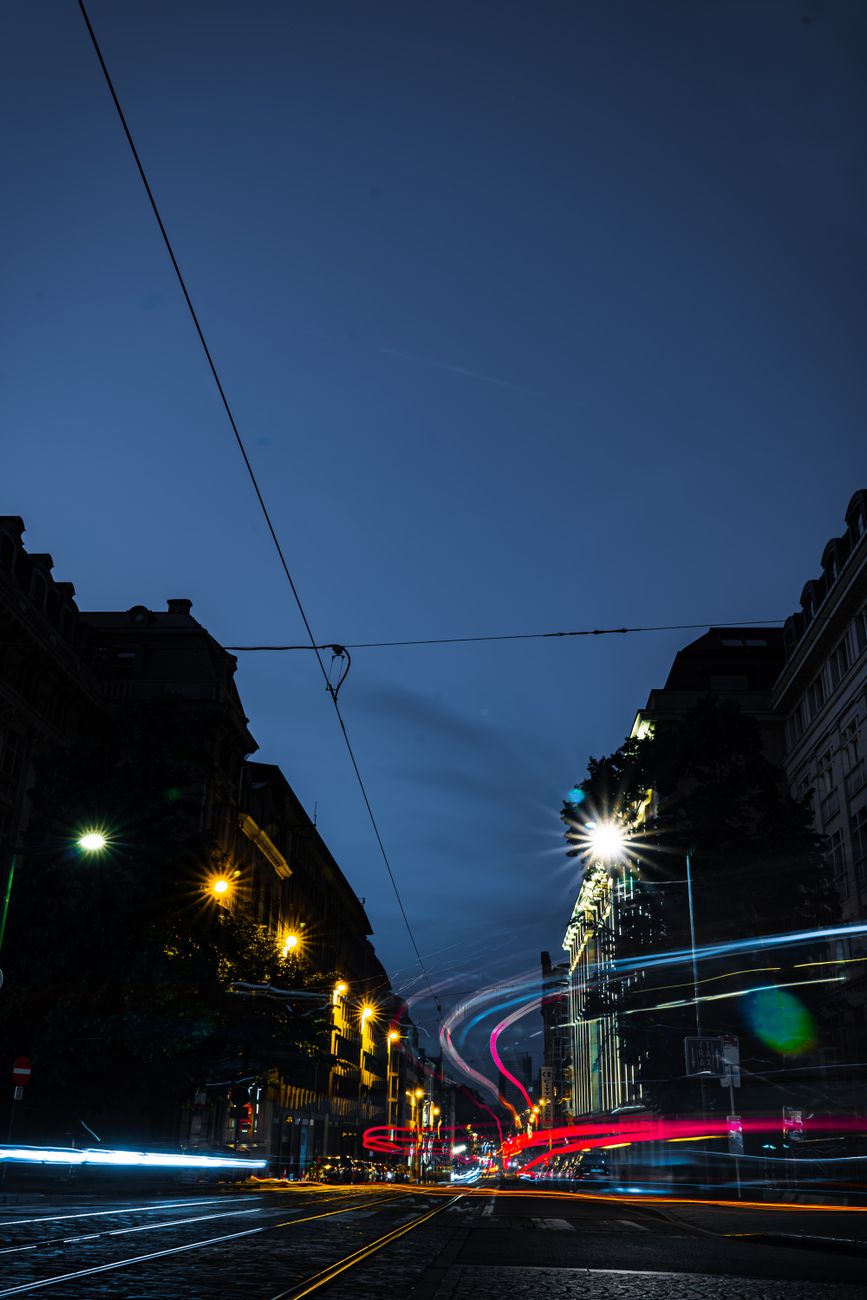 Vibrant night cityscape of Brussels, showcasing dynamic light trails on urban streets.