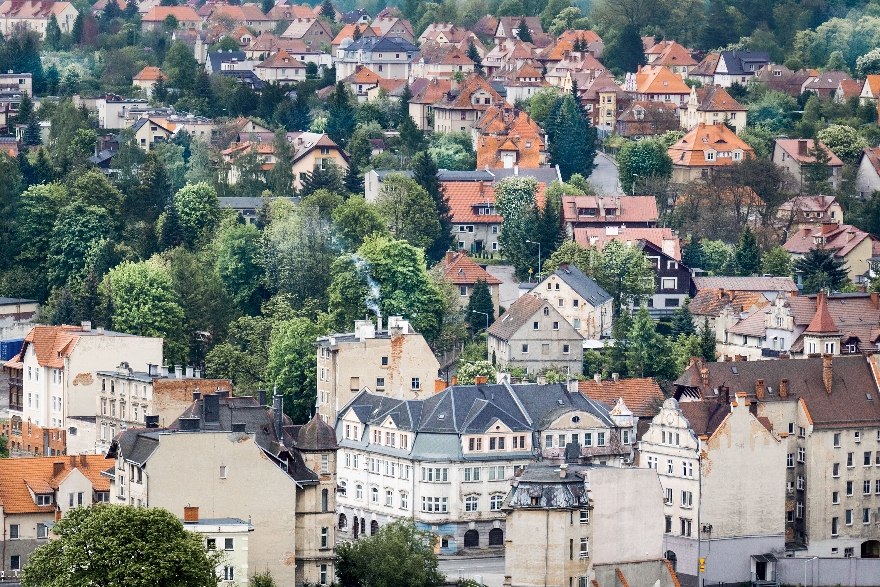 Charming aerial view of Kłodzko's residential architecture, nestled among vibrant trees in Lower Silesia, Poland.