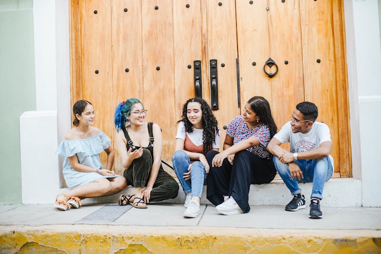 Friends Sitting By Wooden Door