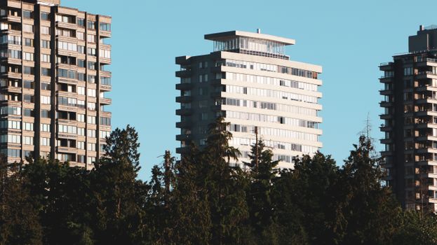 Contemporary apartment buildings in North Vancouver, BC against a clear blue sky.