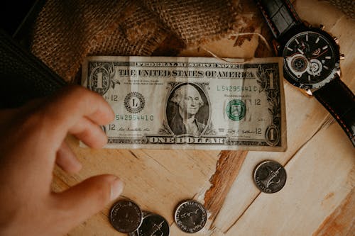 Hand of a Man Reaching for a Dollar Bill