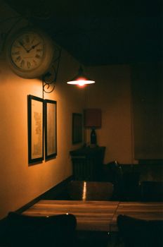 A vintage cafe corner with a clock and warm lighting evokes nostalgia and charm.