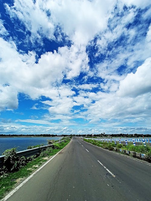 Foto stok gratis air biru, jalan pesisir, langit yang indah