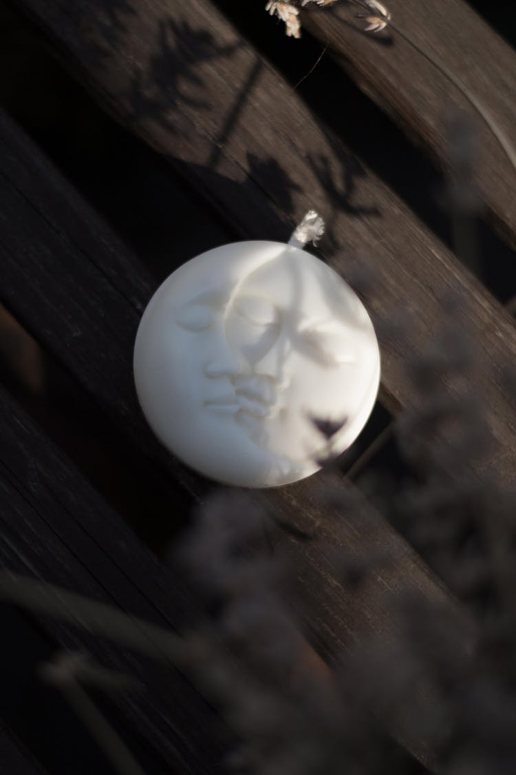 A Candle In The Shape Of A Moon With Faces