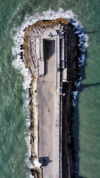 Aerial view of a pier in Mar del Plata, Argentina, surrounded by ocean waves.